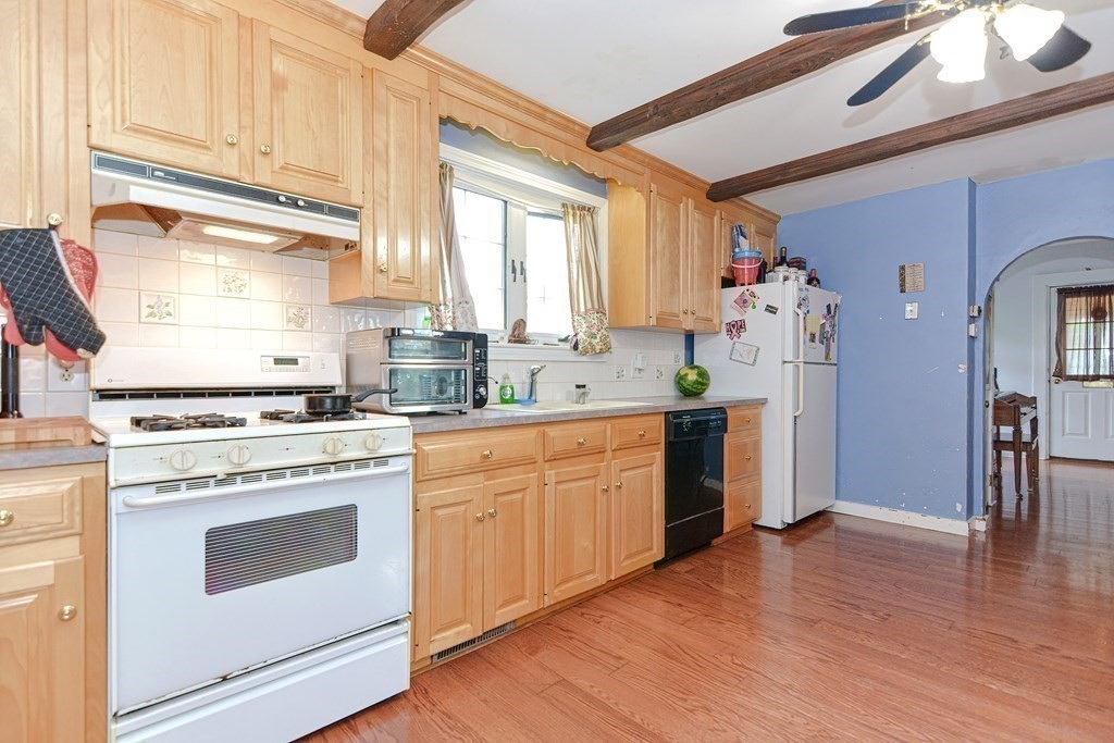 38 Grant Street Milford, MA 01757 - Photo 12 of 42 a kitchen with granite countertop white cabinets and white appliances