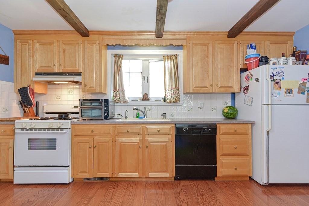 38 Grant Street Milford, MA 01757 - Photo 14 of 42 a kitchen with granite countertop white cabinets and white appliances