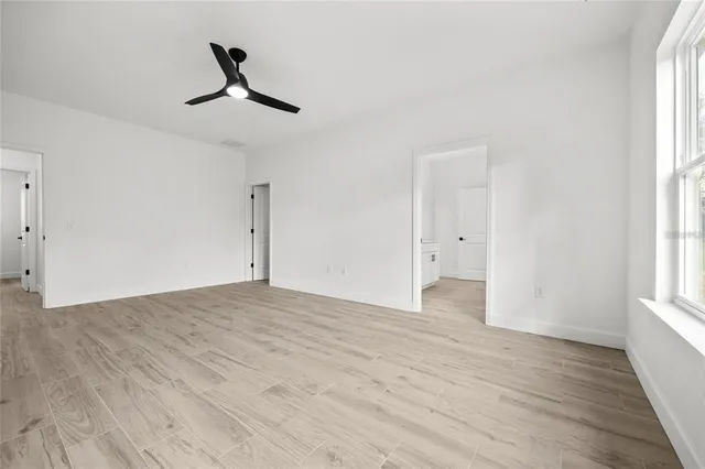 a view of empty room with wooden floor and window