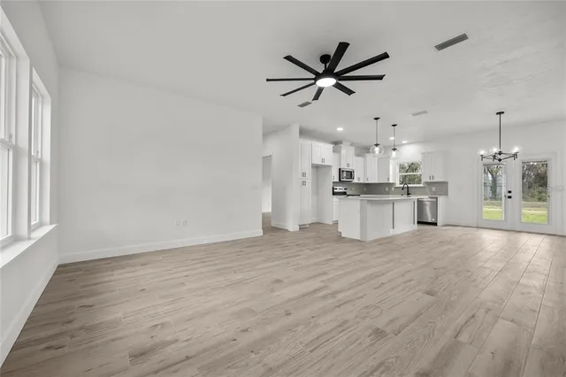 a view of a kitchen with a sink wooden floor and a window