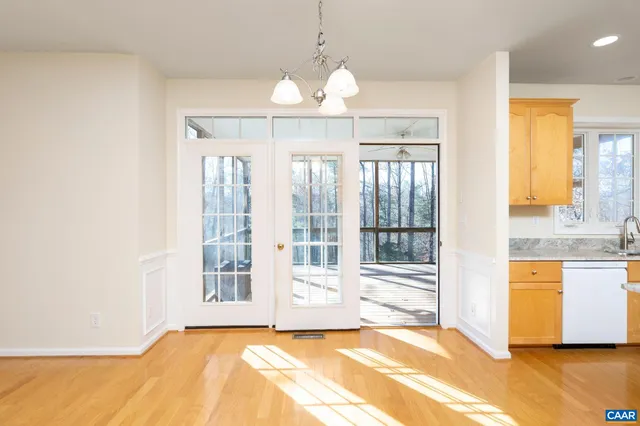 a view of an empty room with a window and a kitchen