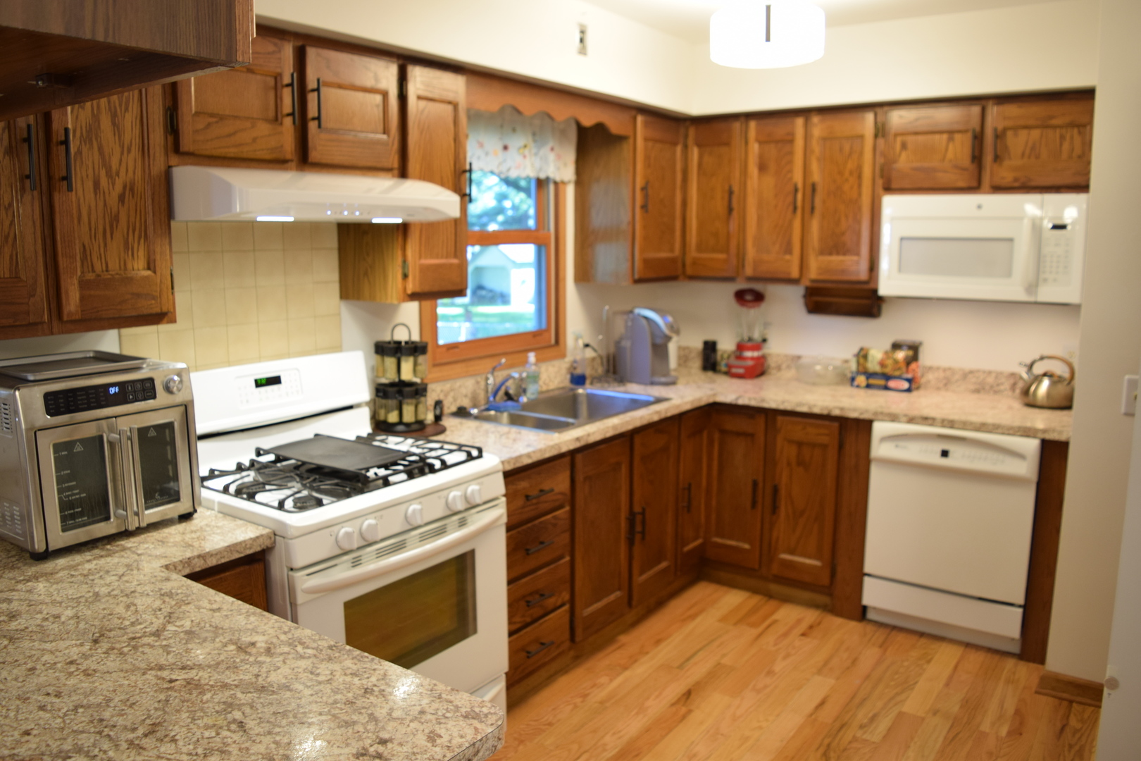 574 Ada Street Cary, IL 60013 - Photo 7 of 23 a kitchen with a stove a sink and a microwave