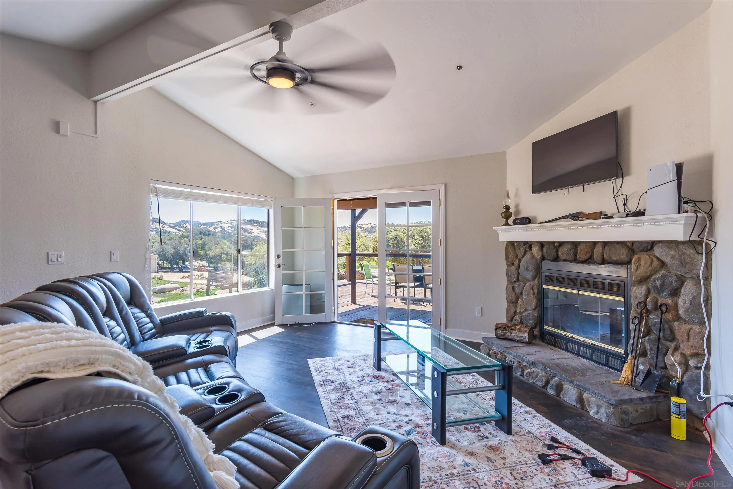 19150 High Glen Road Alpine, CA 91901 - Photo 22 of 56 a living room with furniture a flat screen tv and a fireplace