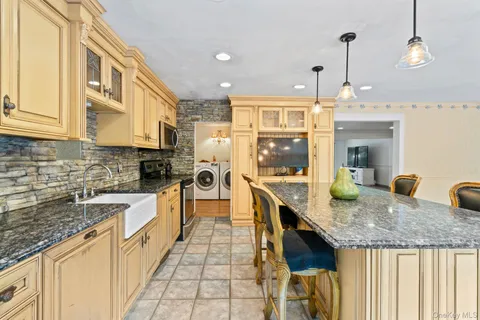 a large kitchen with granite countertop a sink and cabinets