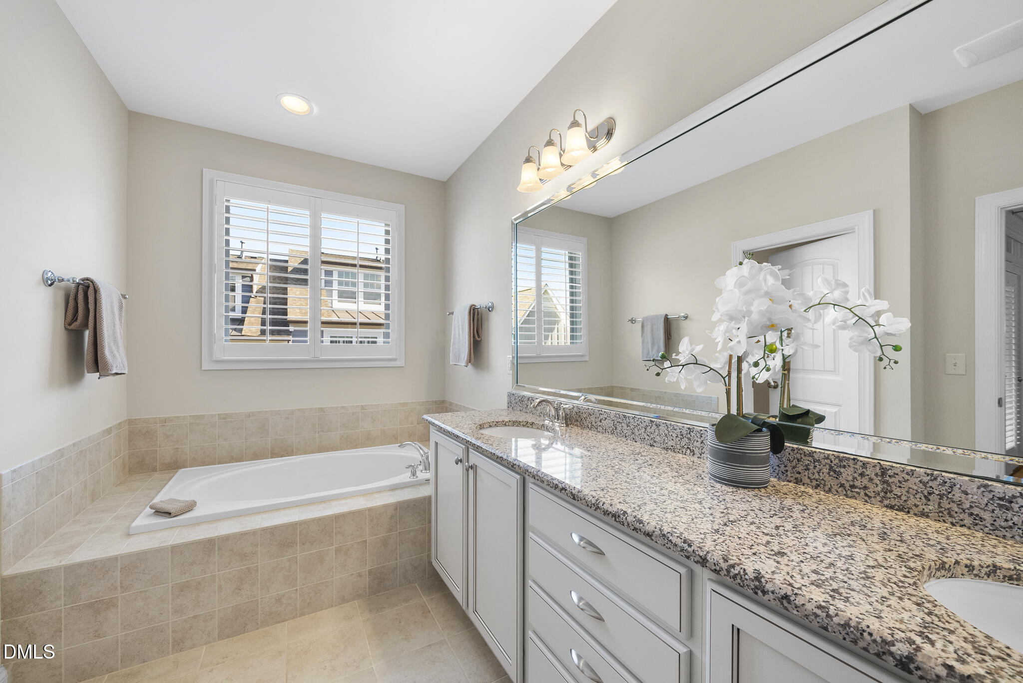 765 Fallon Grove Way Raleigh, NC 27608 - Photo 7 of 43 a bathroom with a granite countertop tub a double vanity sink a window and a mirror