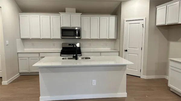 a kitchen with kitchen island granite countertop a sink stainless steel appliances and white cabinets