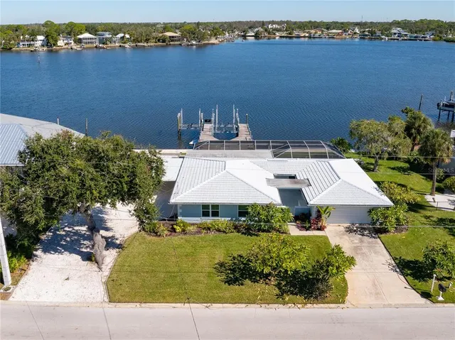 an aerial view of a house with a yard and lake view