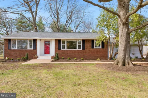 a view of a yard in front of a house with large tree