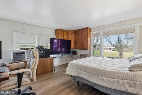 a bedroom with a bed and large windows