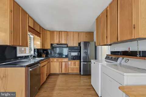 a kitchen with stainless steel appliances granite countertop a refrigerator sink stove microwave and cabinets