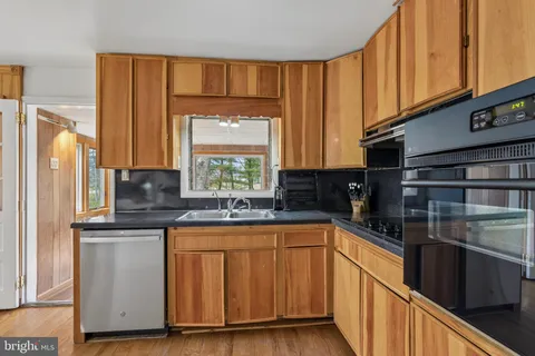 a kitchen with stainless steel appliances granite countertop a sink a stove cabinets and a microwave oven