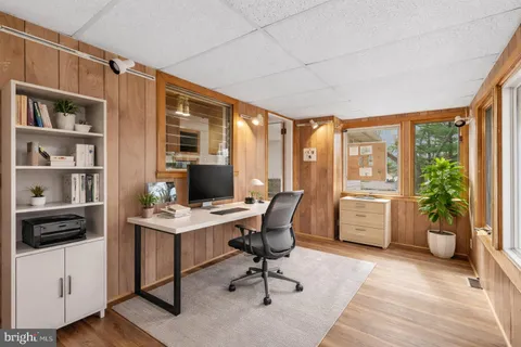 a view of a workspace with furniture and a window