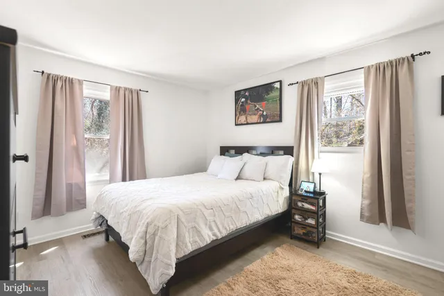 a bedroom with a bed lamp and a large window