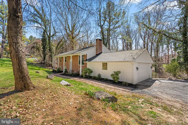 a view of a house with a yard covered in the forest