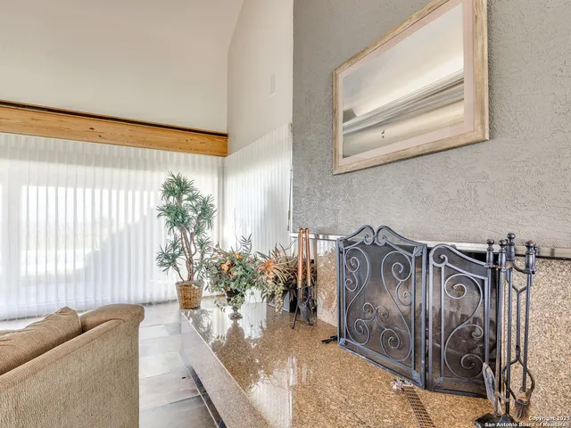 a kitchen with granite countertop a sink a stove a refrigerator and white cabinets