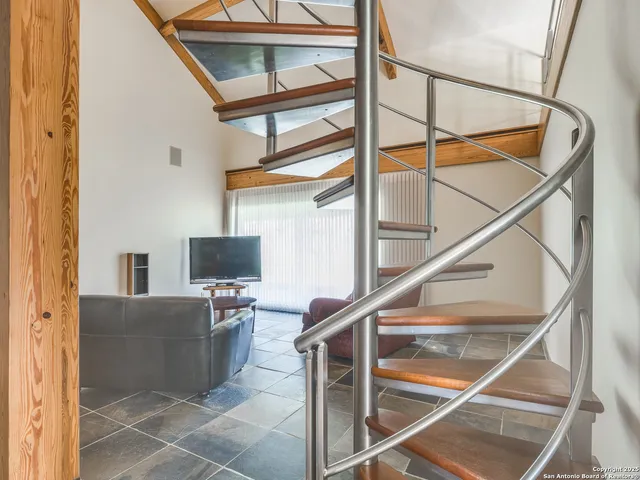 a kitchen with stainless steel appliances kitchen island granite countertop a sink a stove a dining table and chairs with white cabinets