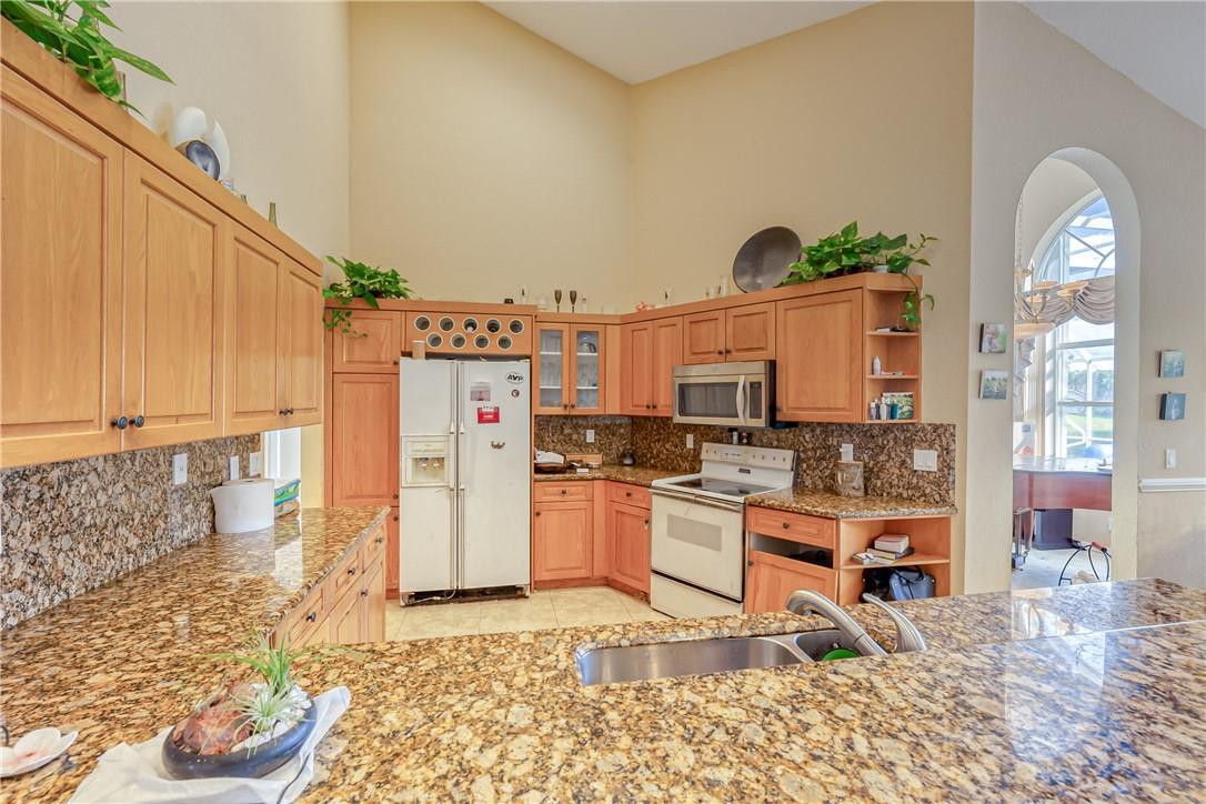 22372 Collington Drive Boca Raton, FL 33428 - Photo 14 of 22 a kitchen with stainless steel appliances kitchen island granite countertop a refrigerator and stove