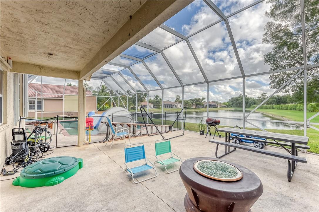 22372 Collington Drive Boca Raton, FL 33428 - Photo 21 of 22 a view of a patio with a table chairs and a small yard