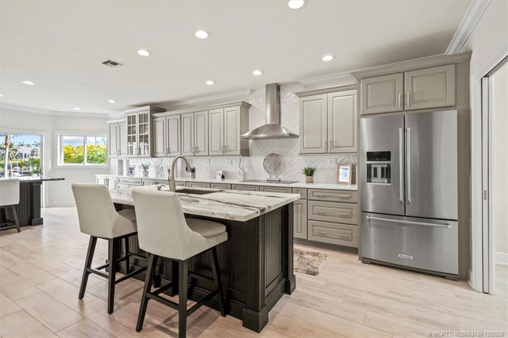 3404 Southeast Inlet Harbor Trail Stuart, FL 34996 - Photo 12 of 32 a kitchen with stainless steel appliances granite countertop a dining table chairs refrigerator and sink