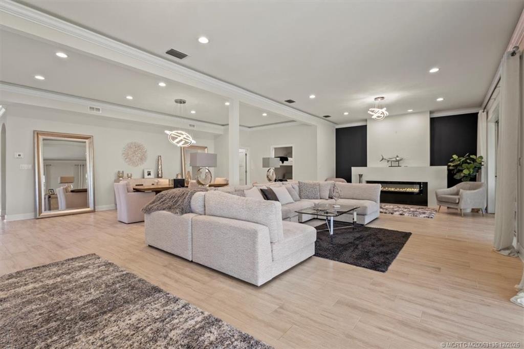 3404 Southeast Inlet Harbor Trail Stuart, FL 34996 - Photo 7 of 32 a living room with furniture a fireplace and a view of kitchen