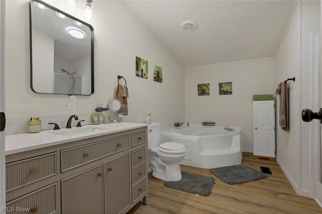 3750 Cannelville Road Roseville, OH 43777 - Photo 12 of 33 Bathroom with vanity, light wood-style floors, a garden tub, and a shower