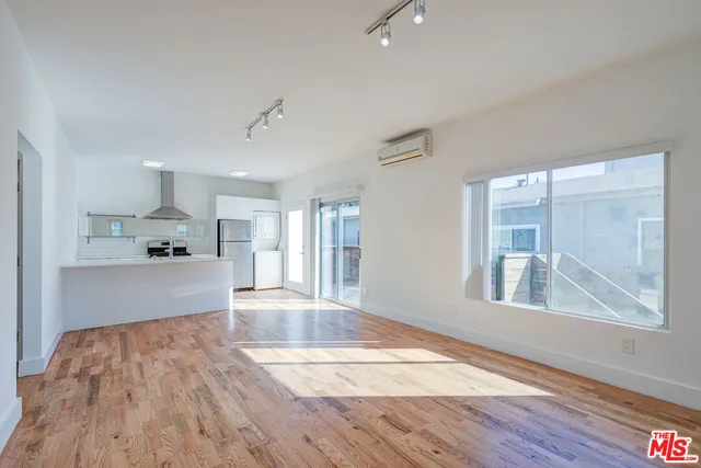 a view of a kitchen with wooden floor and windows
