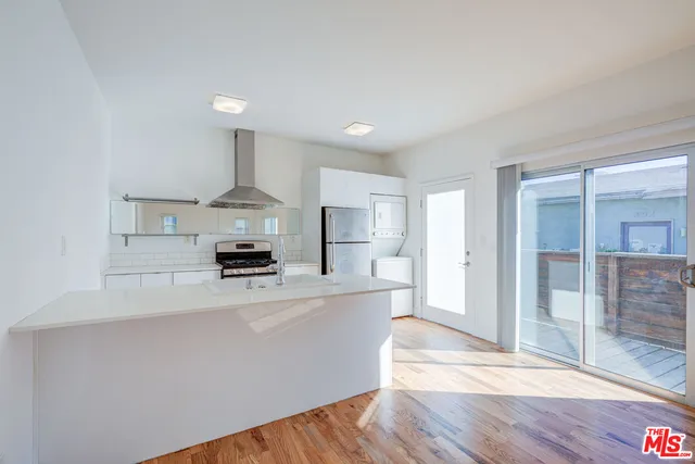 a kitchen with kitchen island a refrigerator sink and stove