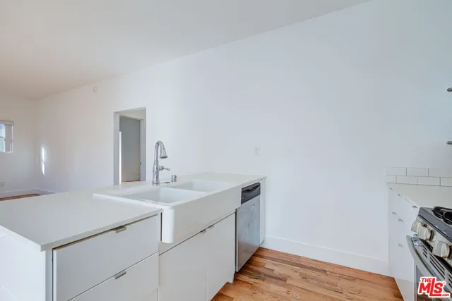 a kitchen with a refrigerator and a stove top oven