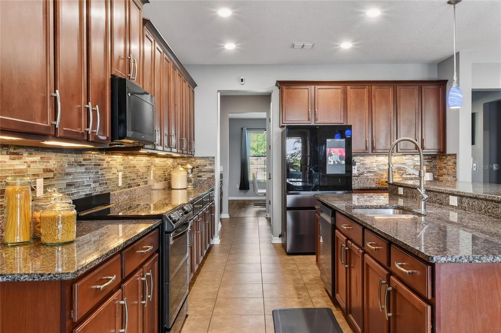 232 Magneta Loop Auburndale, FL 33823 - Photo 5 of 80 a kitchen with stainless steel appliances granite countertop counter space a sink and cabinets