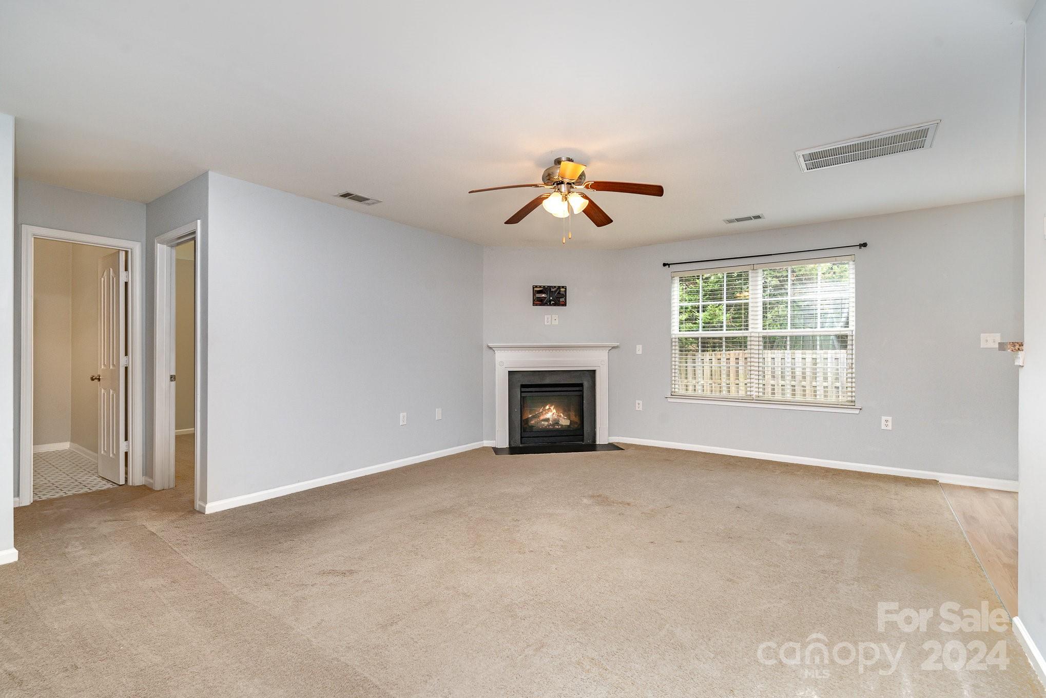 1004 Marcus Street Indian Land, SC 29707 - Photo 13 of 48 a view of an empty room with a fireplace and a window