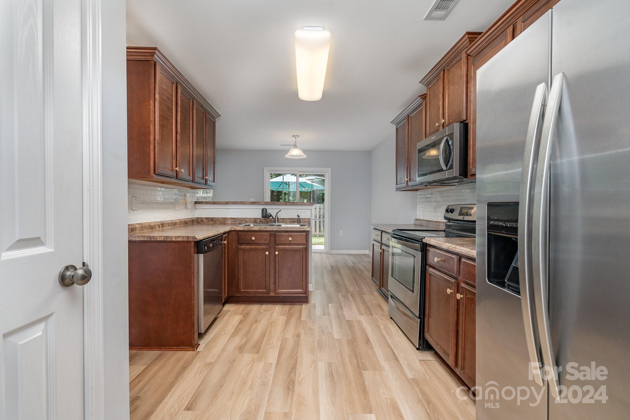1004 Marcus Street Indian Land, SC 29707 - Photo 18 of 48 a kitchen with stainless steel appliances granite countertop a refrigerator a stove top oven a sink and dishwasher