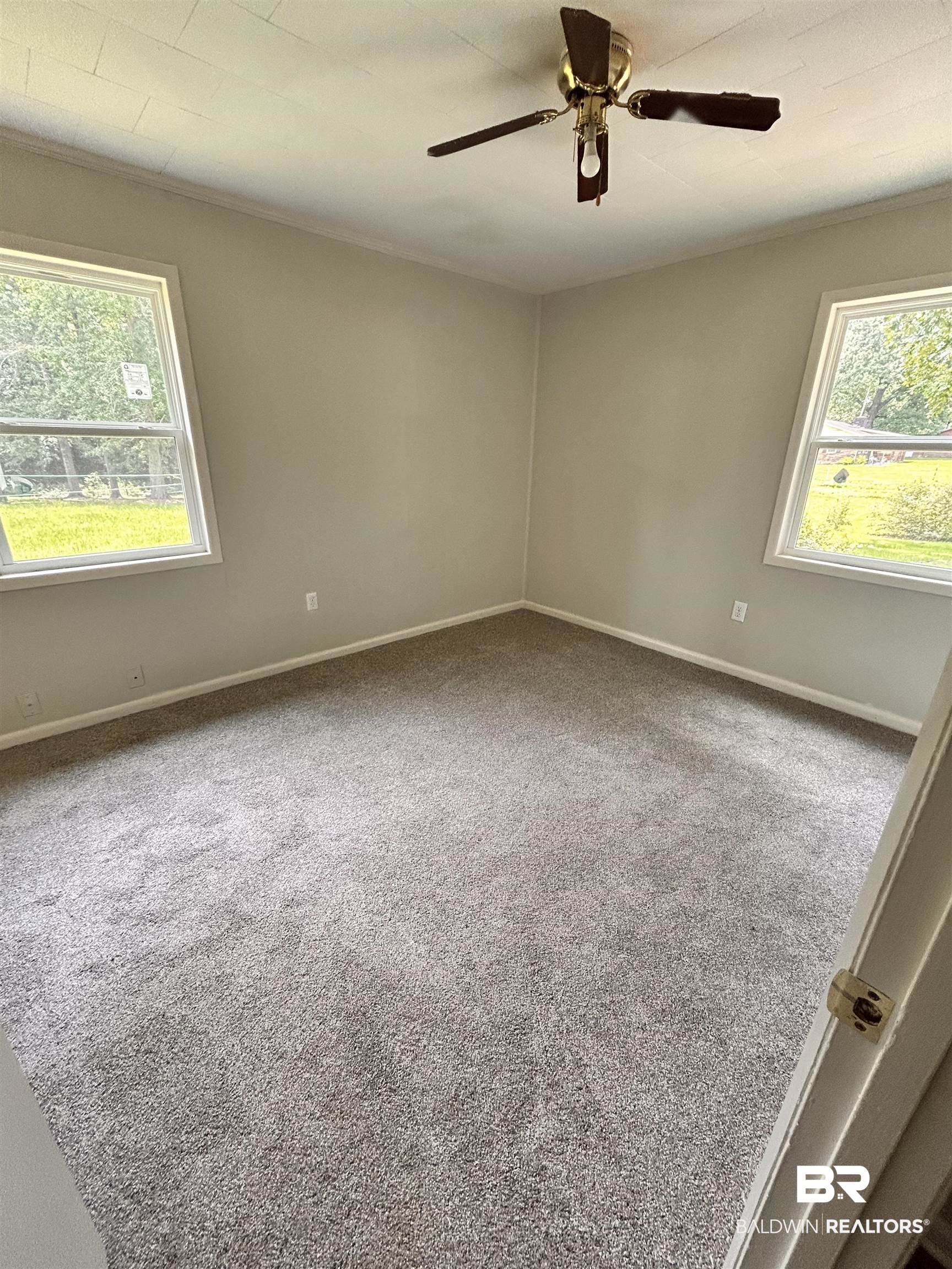 7870 Bradley Road Brewton, AL 36426 - Photo 6 of 8 Carpeted room with a ceiling fan, crown molding, and two windows