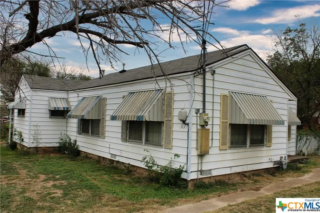 a view of small house with a yard