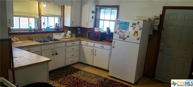 a kitchen with a refrigerator and a sink
