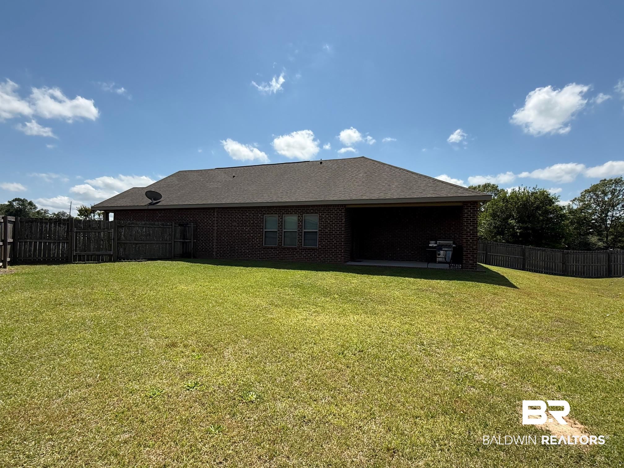 2996 Notsram Court Mobile, AL 36695 - Photo 2 of 16 Rear view of house featuring fence, a yard, and brick siding