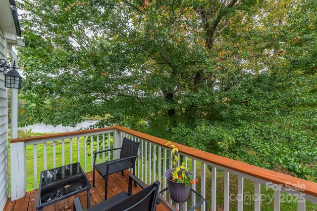 a view of a balcony with chairs and wooden fence