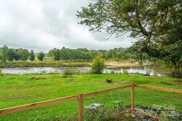 a view of green field with trees in the background