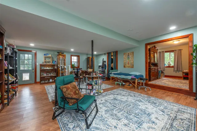 a living room with furniture a dining table and chairs with wooden floor