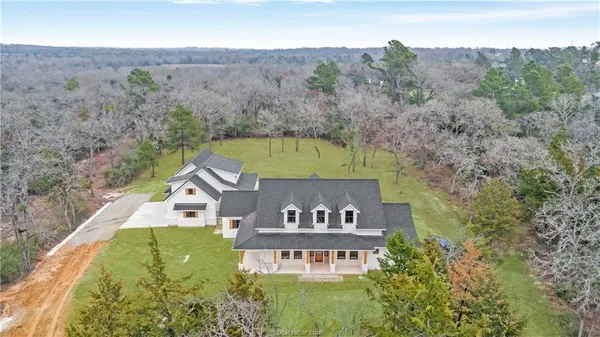 an aerial view of a house swimming pool and mountains