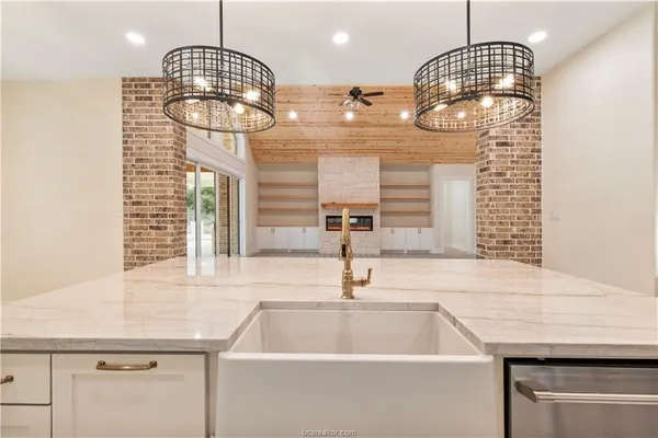 a kitchen with a sink cabinets and chandelier