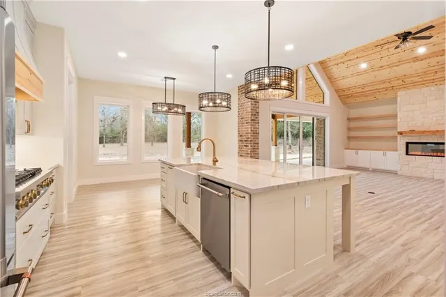 a kitchen with stainless steel appliances granite countertop a stove and wooden floor