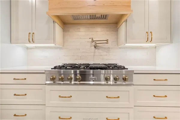 a kitchen with white cabinets and appliances