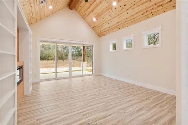 a view of empty room with wooden floor and fireplace