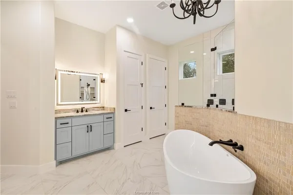 a bathroom with a tub sink and mirror