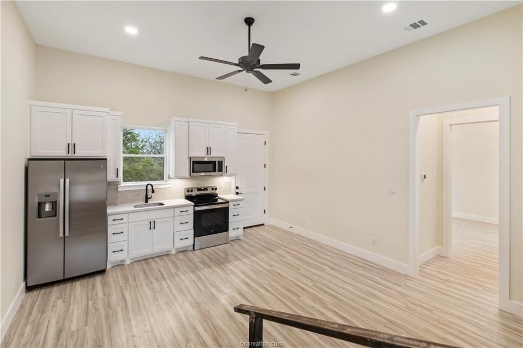 Lot 9 Old Hickory Trail Franklin, TX 77856 - Photo 36 of 41 a kitchen with granite countertop a refrigerator oven a sink dishwasher and white cabinets with wooden floor