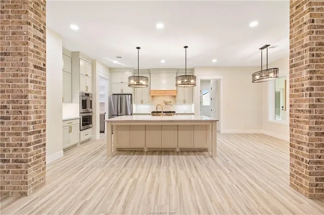 a large kitchen with kitchen island a sink stainless steel appliances and cabinets