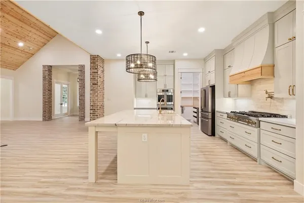 a large kitchen with granite countertop a stove and a sink