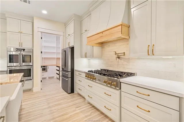 a kitchen with stainless steel appliances granite countertop a stove a refrigerator and a refrigerator