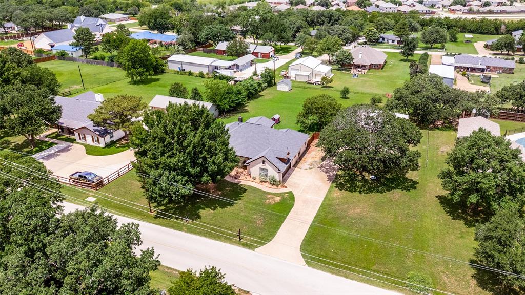 5643 West Caylor Road Fort Worth, TX 76244 - Photo 34 of 37 Single-story residence featuring a dark shingle roof, light-colored exterior, and an expansive concrete driveway