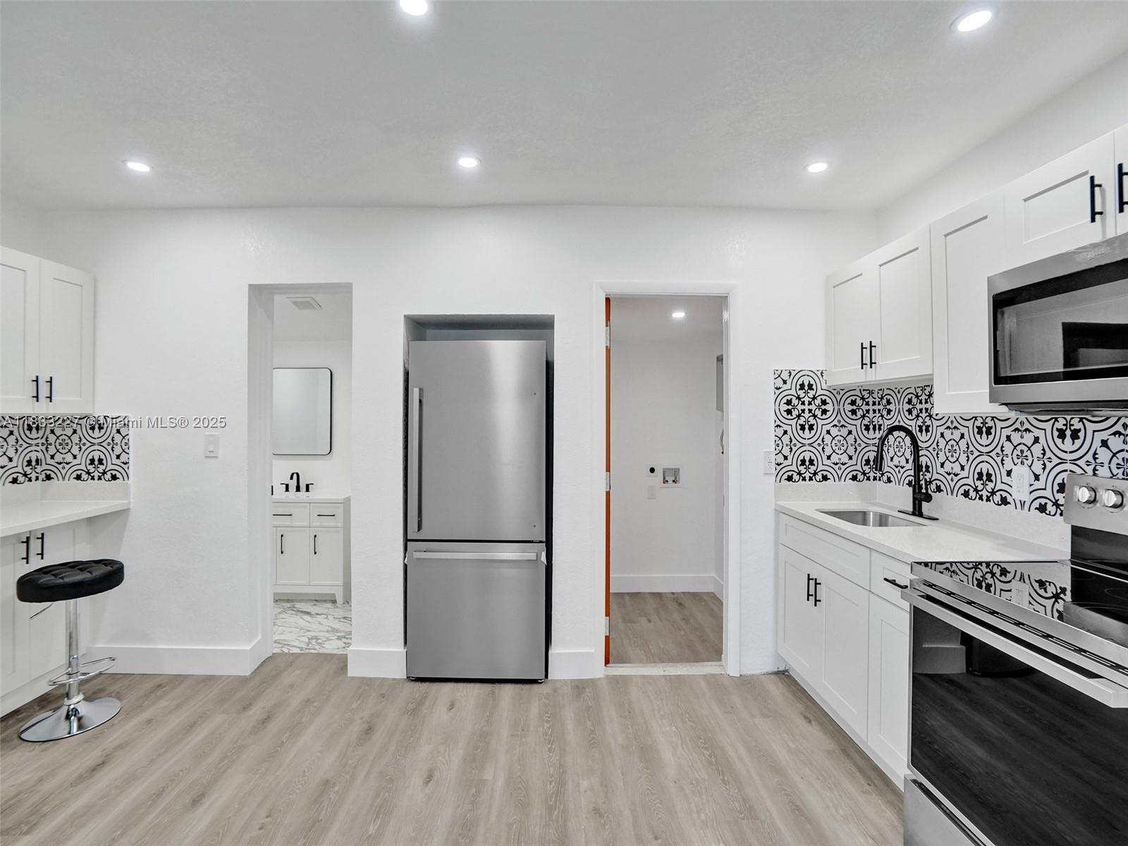 905 Southwest 22nd Street Fort Lauderdale, FL 33315 - Photo 10 of 25 a kitchen with stainless steel appliances a refrigerator stove and sink